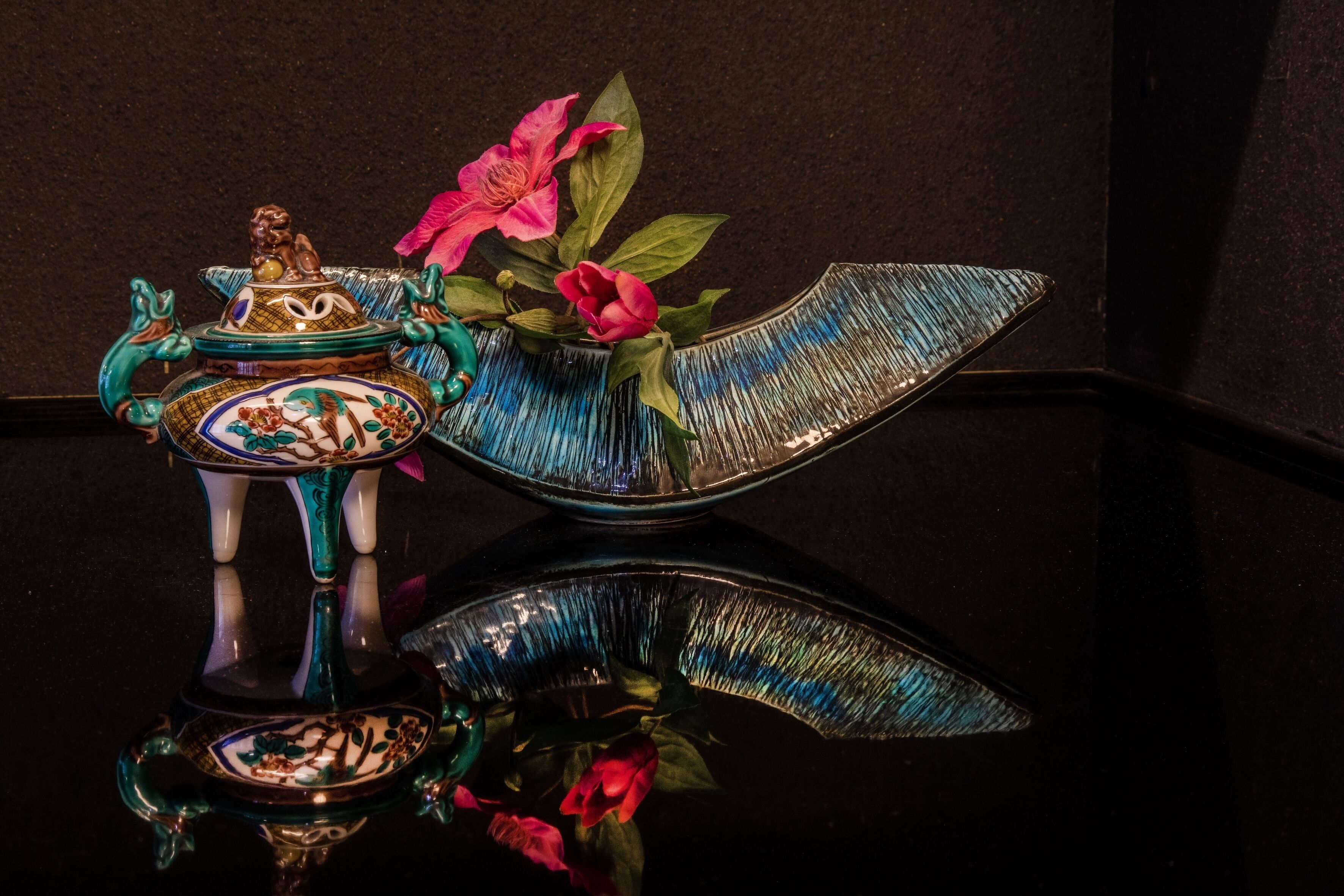 A decorative ceramic piece with a floral design and a blue bird-shaped bowl.