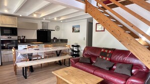 Un espace de vie moderne comprenant un coin repas, une cuisine et un escalier.