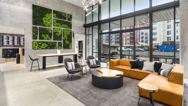 A modern interior with a seating area, a desk, and a large window with a city view. - Elegant design meets optimal location amid the natural beauty of Downtown Redmond. (Redmond)