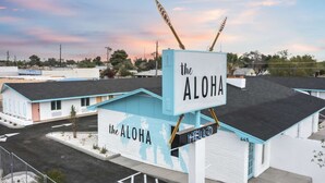 A motel named "The Aloha" with a distinctive sign and a small building with a pink door. - Kaelua Studio suite liʻiliʻi (Chandler)