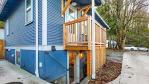A two-story house with a wooden deck and a garage door. - CC01 - Columbia City Urban Studio (Seattle)