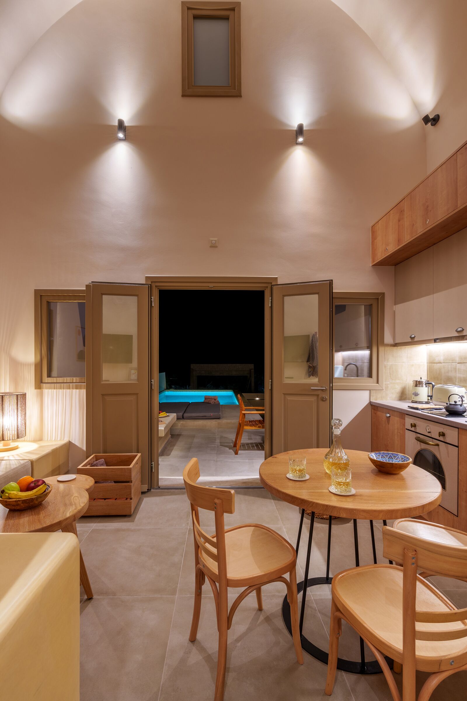 A compact living space with a dining area, kitchen, and a view into a bedroom.
