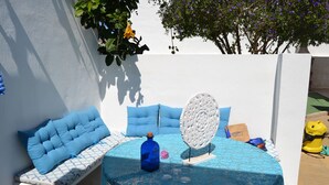Ein runder Tisch mit blauer Tischdecke, einer blauen Flasche und einem weißen Dekorationsstück.