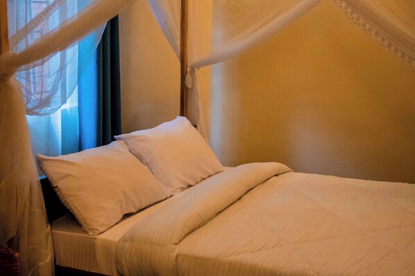 A neatly made bed with white linens and a canopy. - Bamboo Village (Arusha)