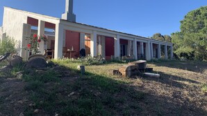A modern building with a long, single-story structure, large windows, and a chimney.