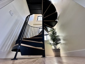 Stunning spiral staircase leads to an upper floor, surrounded by natural beauty.