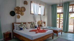 A wooden bed with a white mattress, a bedside table, and a patterned rug. - HABER HOTEL & SPA (Matemwe)