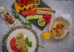 A breakfast spread with various fruits, vegetables, and bread on a table. - HABER HOTEL & SPA (Matemwe)