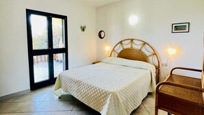 Ein Schlafzimmer mit einem Bett, einem Fenster, einer Wanduhr und einer Wandleuchte.