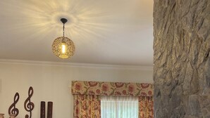 Un salon comprenant un canapé, une table basse, une cheminée et un mur décoratif orné de notes de musique.