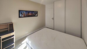 A bedroom with a bed, a wardrobe, a shelf unit, and a wall-mounted picture. - Awesome home in Portiragnes (Portiragnes)