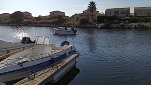 A marina with boats docked, calm water, and residential buildings in the background. - À 10 Minutes de la Plage, Petite Maison au Calme Avec Patio (Le Barcarès)