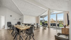 Une salle de réunion spacieuse et moderne, dotée d’une grande table, de sièges confortables et offrant une vue sur un chantier de construction.