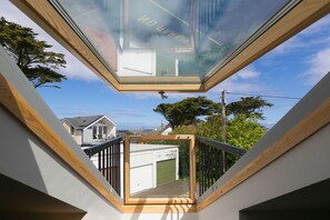 Vue depuis une fenêtre de toit sur un quartier résidentiel, avec un garage et des maisons voisines.