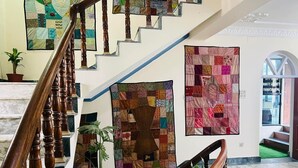 Una escalera con barandillas de madera y una planta en maceta al pie.