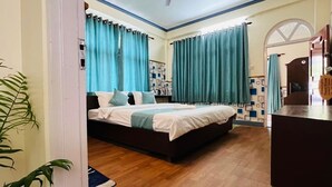 Un dormitorio con cama, cortinas, ventilador de techo y suelo de madera.