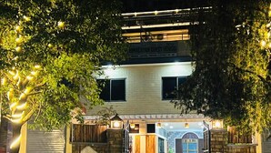 Una casa de huéspedes con fachada de ladrillo, un letrero y una entrada con portón.