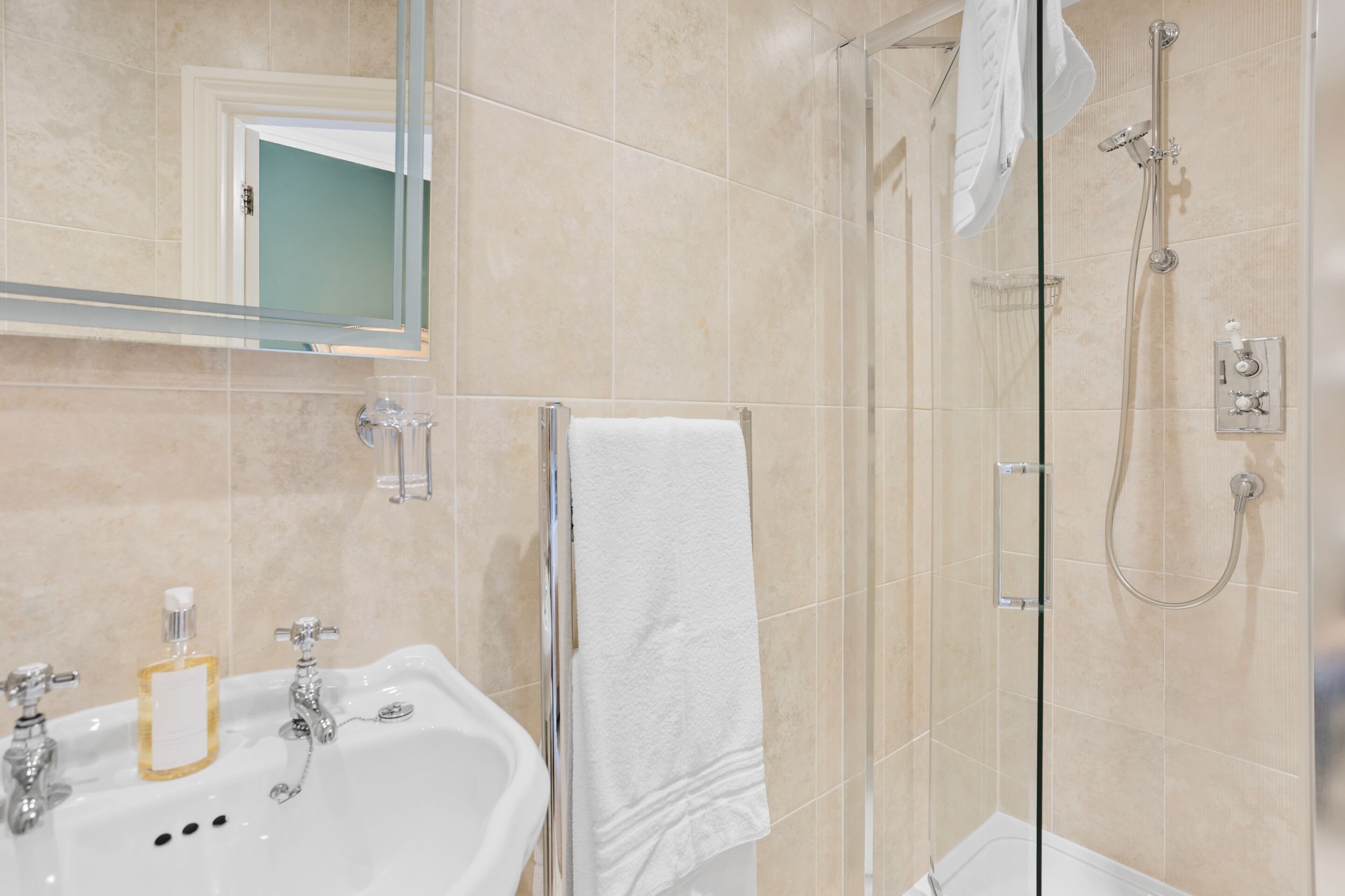 Ein Badezimmer mit Waschbecken, Spiegel und Dusche.