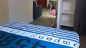Une chambre à coucher comprenant un lit, une armoire, une porte et un couloir menant à une autre pièce.