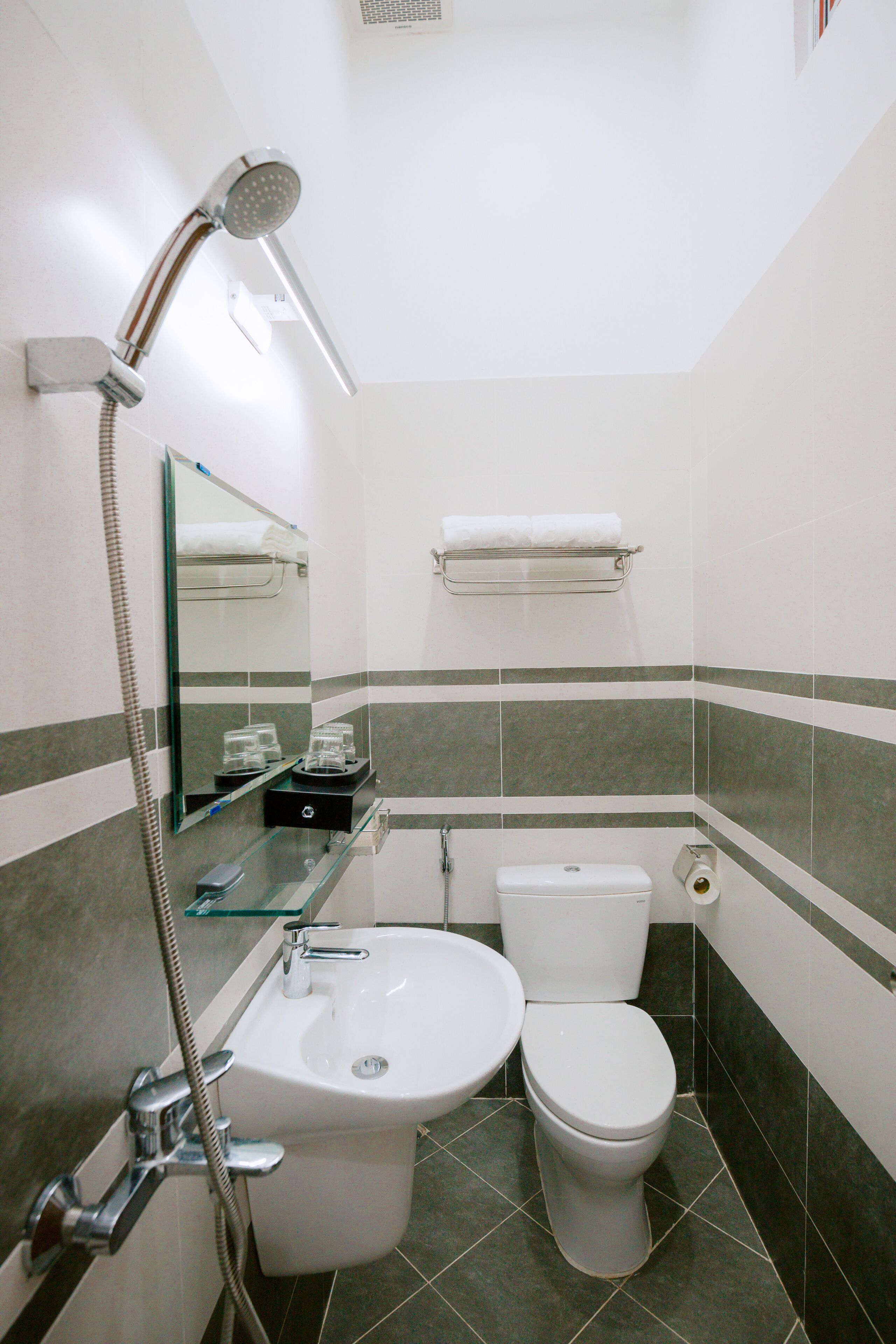 A bathroom with a shower, sink, and toilet.