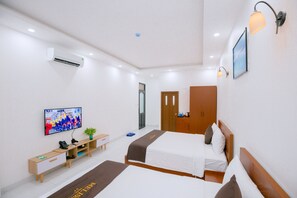 A hotel room with two beds, a desk with a computer, a TV, and a wall-mounted air conditioner. - Melissa Hotel - Vung Tau (Ho Chi Minh City)