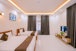 A hotel room with two beds, a TV, a desk with a plant, and a window with curtains. - Melissa Hotel - Vung Tau (Ho Chi Minh City)