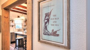 En inramad affisch med Ernest Hemingways roman ”Den gamle och havet” hänger på en vägg med en tydlig struktur.