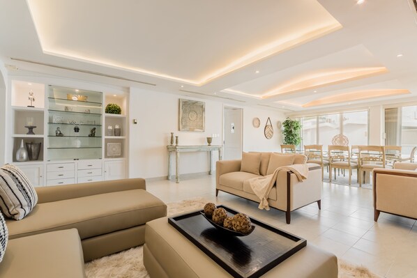 A modern living room with a sofa, coffee table, and dining area.