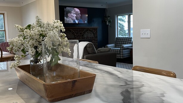 A marble kitchen island with a vase of white flowers. - Highland Hills- Family, Farm, Golf and Goats (Ubly)