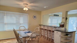 A kitchen with a dining area, wooden chairs, a ceiling fan, and a sign reading 'BEACH HOUSE'. - 6 Bedroom ocean block home with private beach access (Bethany Beach)