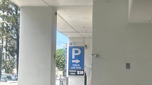 A public car park entrance with a blue sign indicating a $10 parking fee. - Surfers Paradise Beach & Ocean View Unit (Surfers Paradise)