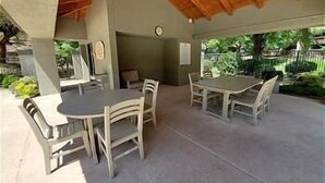 Eine Terrasse im Freien mit Holzboden, einem runden Tisch und vier Stühlen.