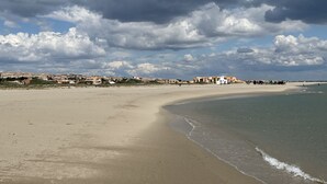 Een strand met een rij gebouwen in de verte.