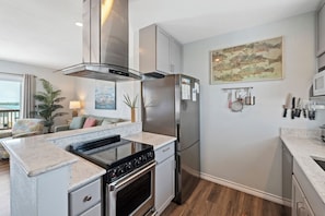 A modern kitchen with a built-in stove, stainless steel appliances, and a marble countertop. - Bay Tree Condos in the heart of Port Aransas!  Amenities include a community poo (Port Aransas)