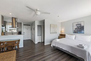 A hotel room with a bed, a dining table with chairs, a kitchen area, and a ceiling fan. - Bay Tree Condos in the heart of Port Aransas!  Amenities include a community poo (Port Aransas)