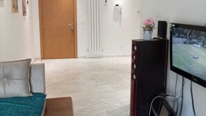 Une chambre d’hôtel avec un canapé, une télévision et une porte en bois.