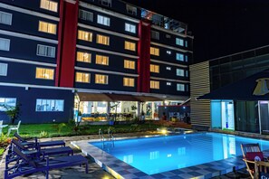 A hotel with a swimming pool, outdoor seating, and a well-lit building facade. - The Warwick Hotel, Nanyuki (Nanyuki)
