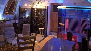 A cozy interior with a wooden table, chairs, and hanging plants.