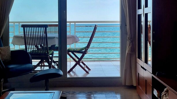 A room with a view of the ocean, a chair, a table, and a TV. - Mediterranean Lookout From Vinaròs (Vinaròs)