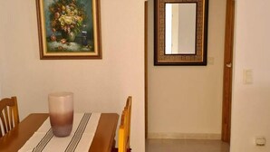 A dining area with a wooden table, red cushioned chairs, a vase, and a painting on the wall. - Mediterranean Lookout From Vinaròs (Vinaròs)