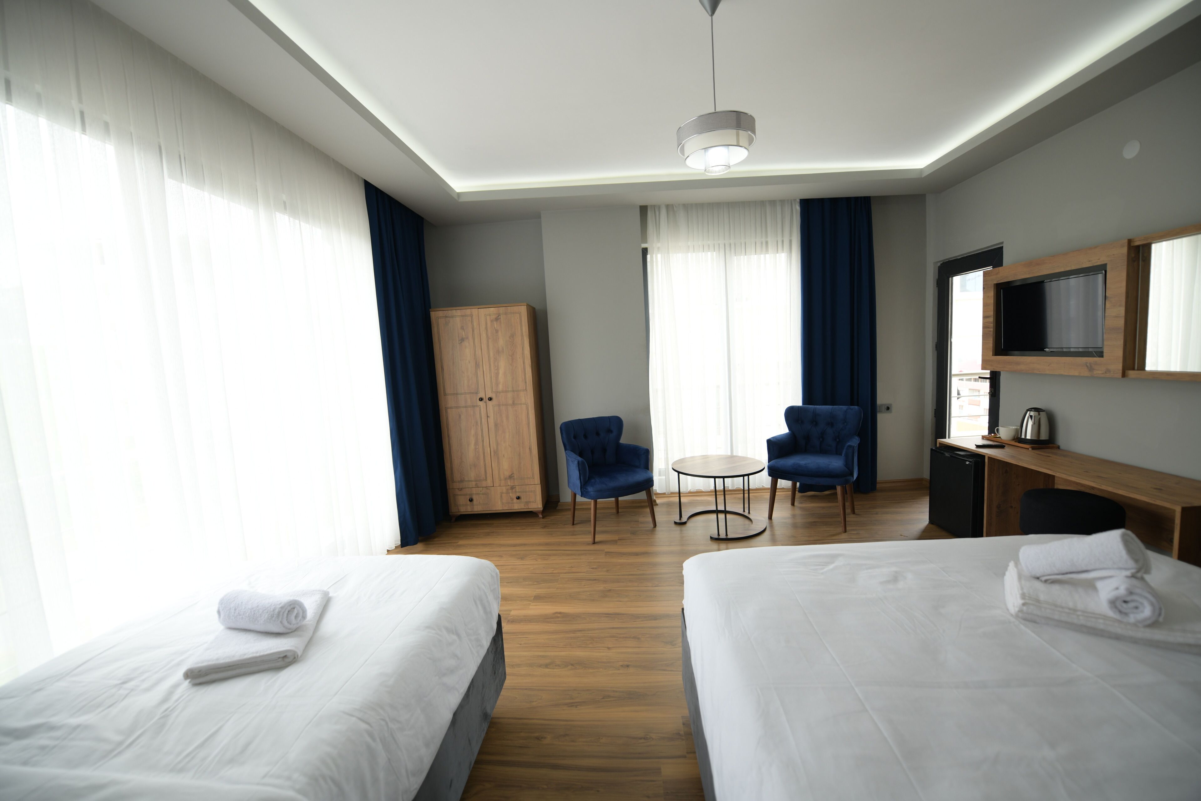 Una habitación de hotel con dos camas, un escritorio, un televisor y una mesita.
