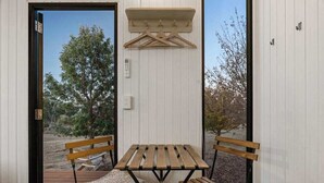 A wooden table and benches in a room with a white wall and a hanging coat rack. - The High Country Views Escape by Tiny Away (Table Top)