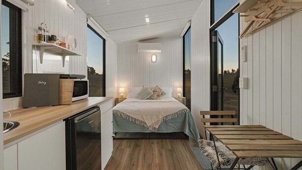 A compact bedroom with a bed, bedside tables, a desk, and a chair. - The High Country Views Escape by Tiny Away (Table Top)