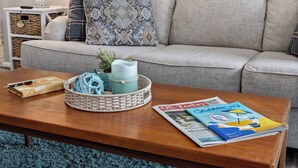 A living room with a sofa, a coffee table, a basket, a candle, and a magazine. - Updated 2BR/2BA Condo in North Ocean City, MD | Indoor + Outdoor Pools | 2 Blocks to Beach | Walk to Food Lion & Restaurants | Sleeps 6 (Ocean City)
