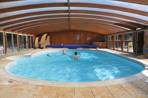 An indoor swimming pool with wooden beams and glass walls. - Domaine de L'Adoux (Montclar)
