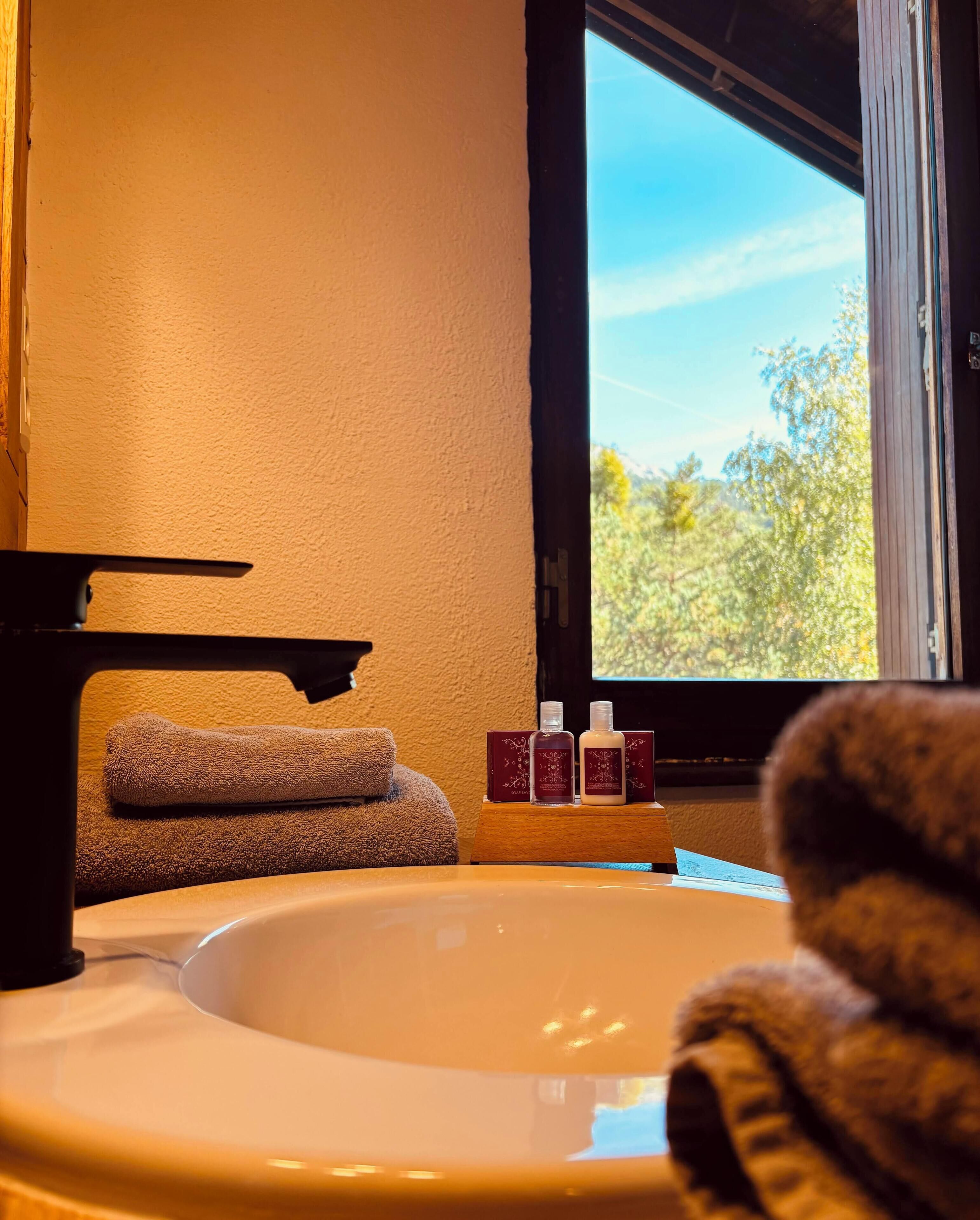 A bathroom with a bathtub, towels, and toiletries.