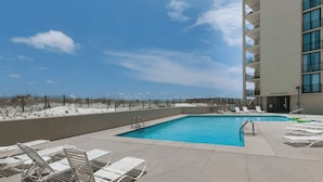A rooftop pool with lounge chairs and a view of the beach. - Wind Drift South East 404 (Orange Beach)