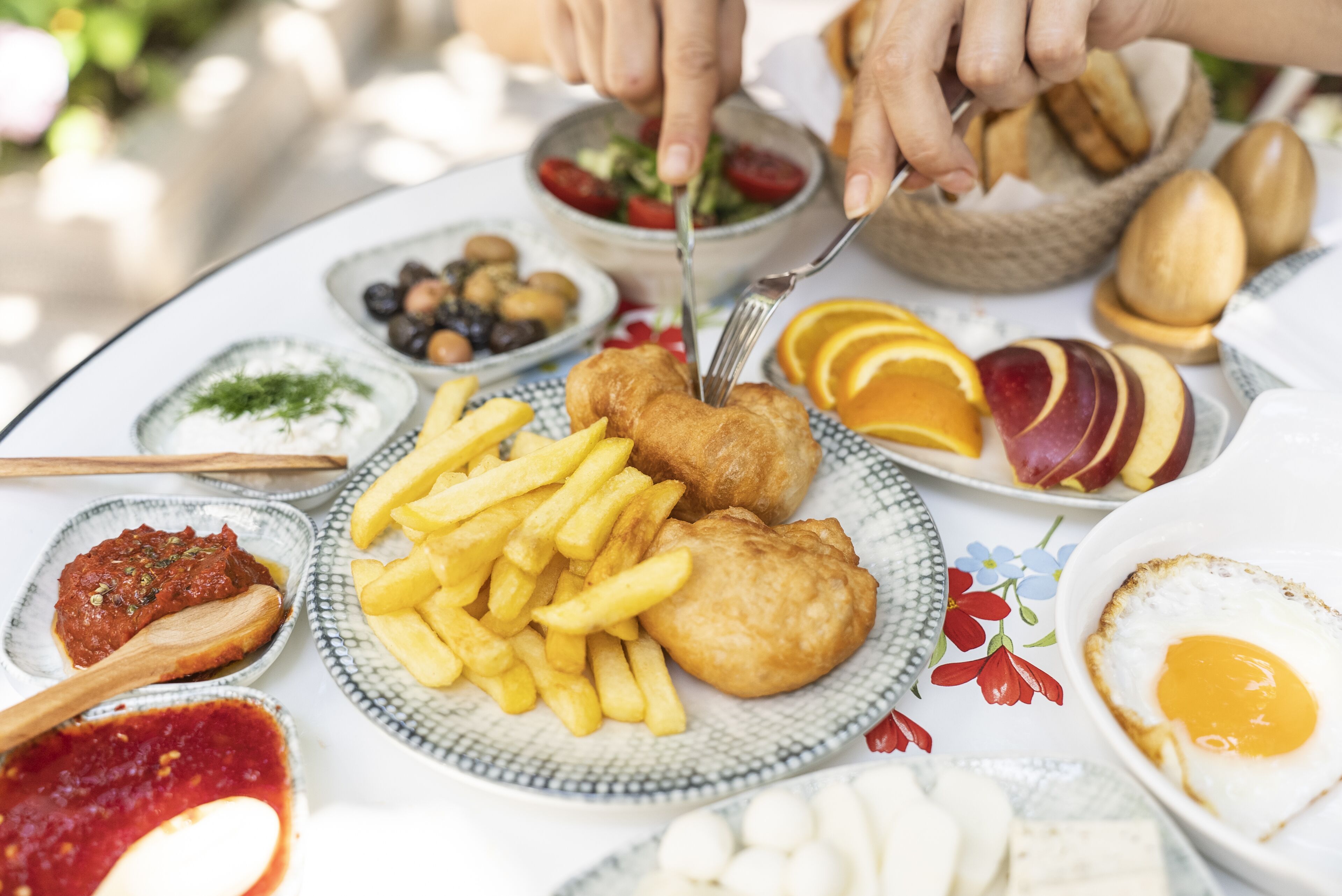 A table with various food items including fish and chips, a fried egg, and a salad.
