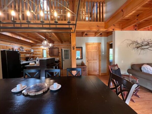 Interior de una cabaña con comedor, cocina y sala de estar.