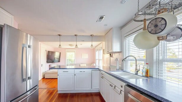 A modern kitchen with stainless steel appliances, white cabinetry, and a central island.